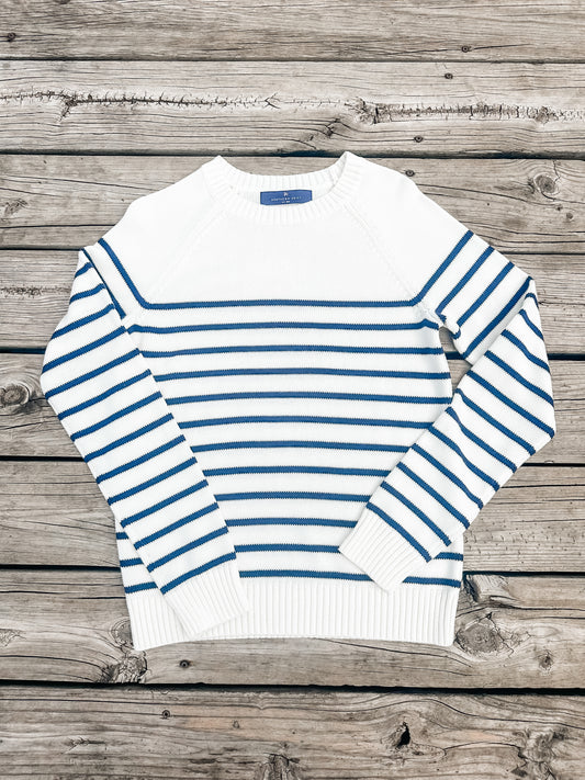 White sweater with blue stripes on a wooden surface
