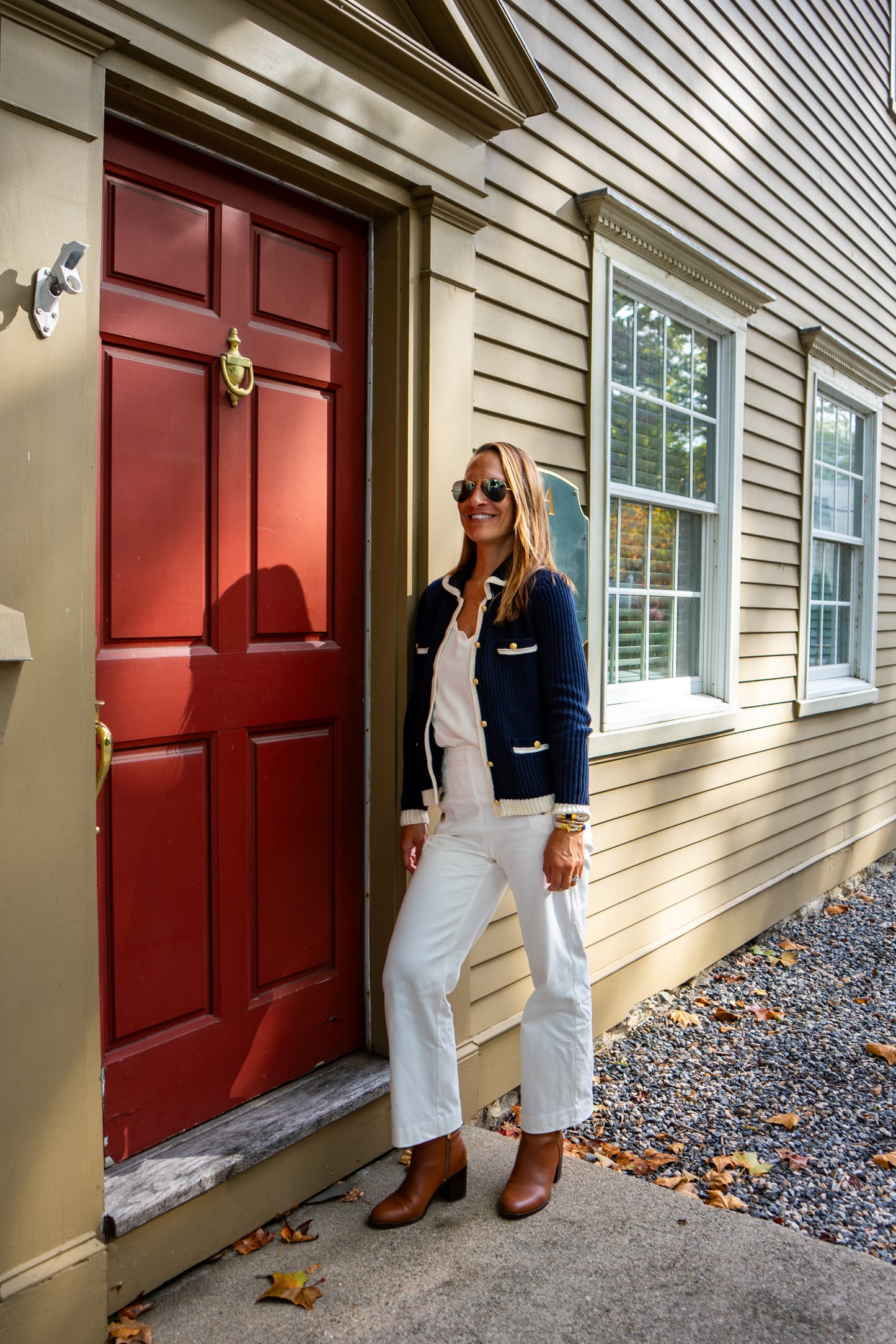 Woman standing outside a house with a red door